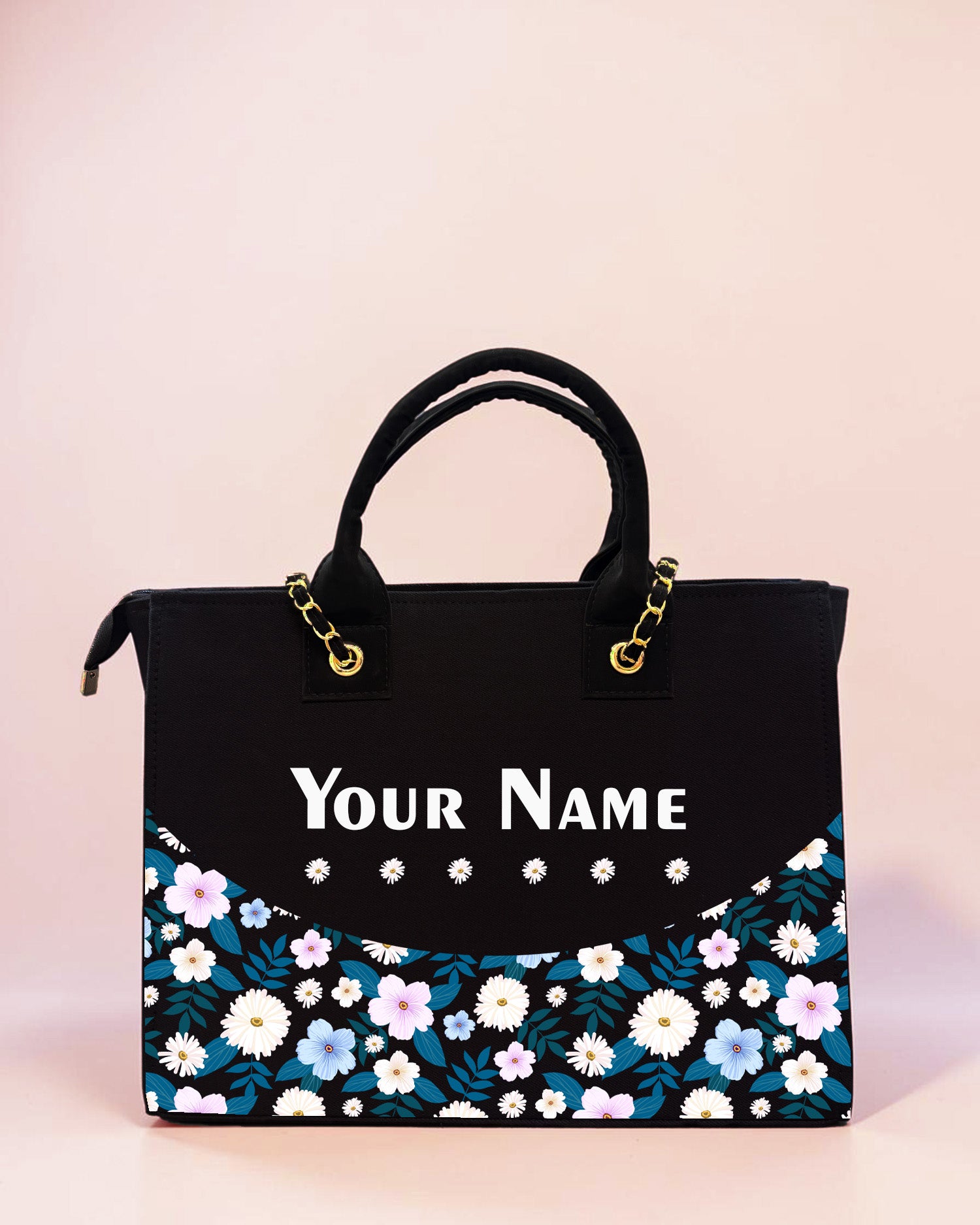Personalized black tote bag with daisy floral artwork and custom name print displayed on a soft pastel background.